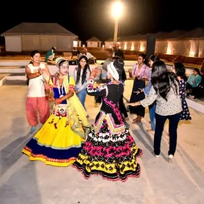 Kalbelia dancers performing with guests at night