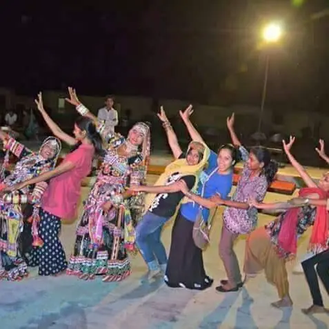Guests dancing with folk artists at a camp night