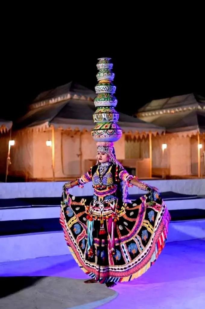 Rajasthani performer balancing pots at a desert camp